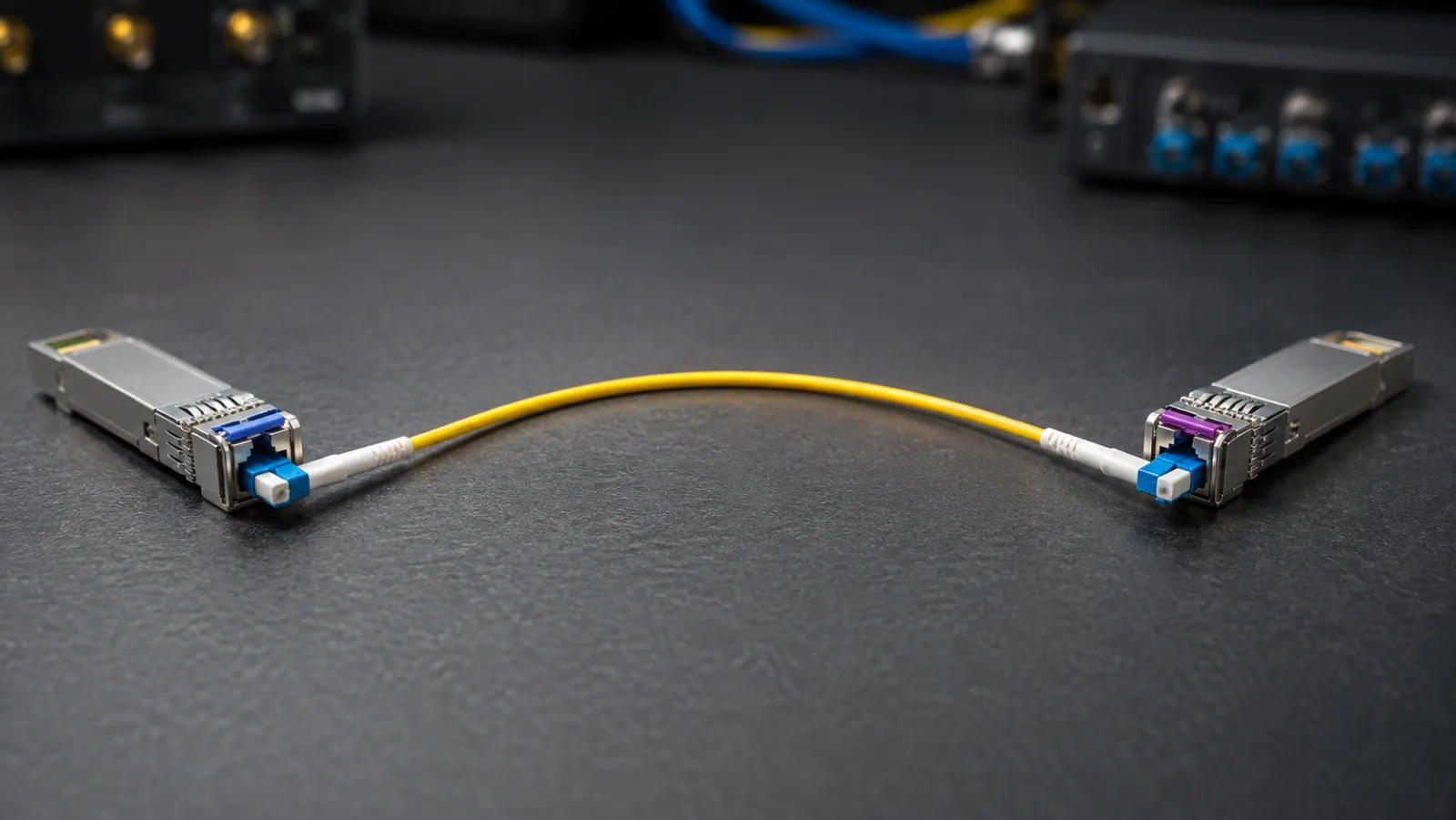 Two single-port optical transceiver modules joined by a yellow fiber jumper